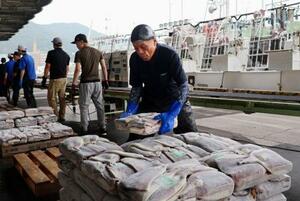 冷凍されたアカイカを仕分ける漁業関係者=7日午前、北海道函館市