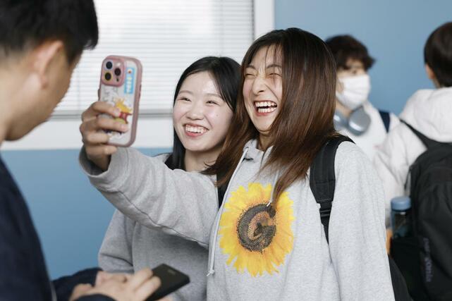 プラハの空港に到着し、笑顔で自撮りするフィギュアスケート女子の坂本花織（右）と中井亜美＝２３日（共同）