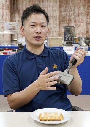 食パン1枚で焼ける「ホットサンドソロ」の説明をする杉山金属の小川陽介営業部長=燕市