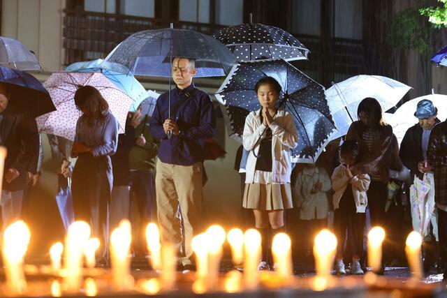 発生時刻に黙祷し合掌する集落の住民ら＝１０月２３日午後５時５６分、小千谷市塩谷