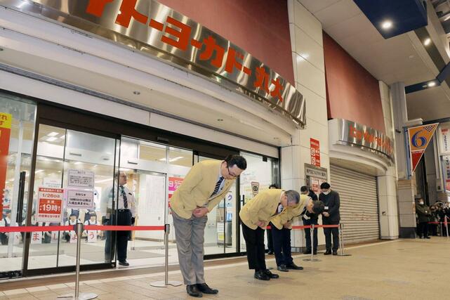 閉店間際、詰めかけた人々に頭を下げる店員＝１月２６日、新潟市中央区のイトーヨーカドー丸大新潟店