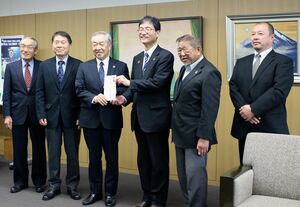 鈴木力市長(右から3人目)に目録を手渡す県央電気工事協同組合の原田和広理事長(同4人目)ら=燕市役所