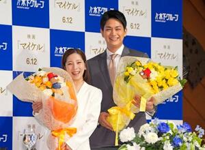 現役引退の記者会見で、花束を手に撮影に応じるフィギュアスケート・ペアの三浦璃来(左)、木原龍一組=28日、東京都内のホテル