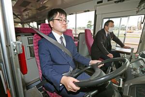 教習車の運転席に座る本間飛向さん。免許取得後、社内の研修などを経てデビューする=新潟市中央区