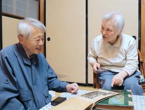 渡辺修さんと齋藤芳乃さんが写る卒業アルバムを前に語り合う渡辺キヱさん(右)と皆川博さん=新潟市東区
