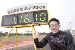 男子20キロ競歩で世界新記録を樹立し、笑顔で写真に納まる山西利和=25年2月、神戸市東灘区