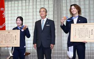 新潟県庁で県民栄誉賞を受賞し、花角英世知事(中央)と記念写真に納まるフィギュアスケートの中井亜美選手(左)とスノーボードの山田琉聖選手=11日午前