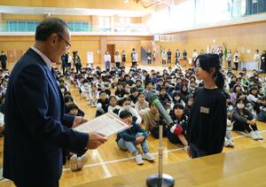 児童代表の井出千森さんに感謝状を贈る渡辺竜五・佐渡市長=佐渡市千種