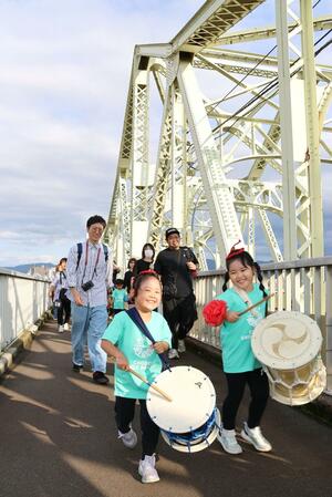 市民らが歩道橋を歩き、祝賀ムードに包まれた「長生橋米寿誕生祭」=長岡市