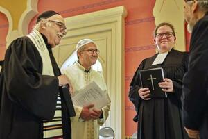 　「開会の祈り」を前に、他宗教の指導者らとあいさつを交わすカディル・サンジュ（左から２人目）＝２０２５年９月、ベルリン（撮影・峯岸進治、共同）