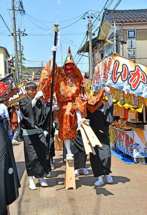 高げたの音を響かせながら練り歩く大名行列の導祖神＝三条市