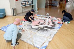 ハワイで揚げる凧を組み立てる関係者=新潟市南区上下諏訪木のしろね大凧と歴史の館