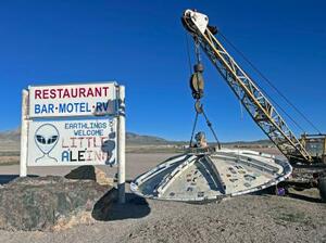 　４月、米ネバダ州レイチェルで、クレーンにつるされたＵＦＯのオブジェと「リトル・エイリイン」の看板（共同）