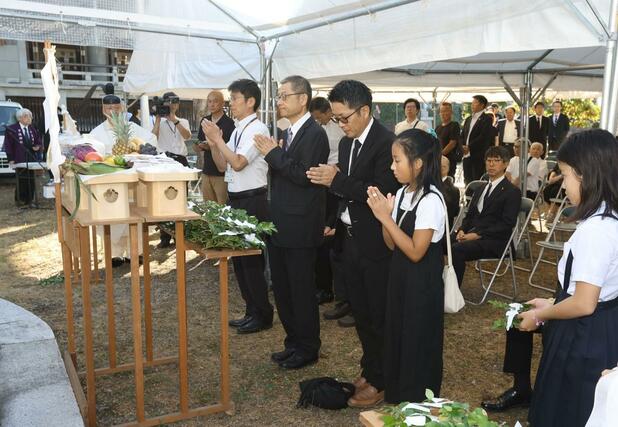 戦災殉難者慰霊塔の前で手を合わせる市民ら＝１日午前６時半ごろ、長岡市表町１