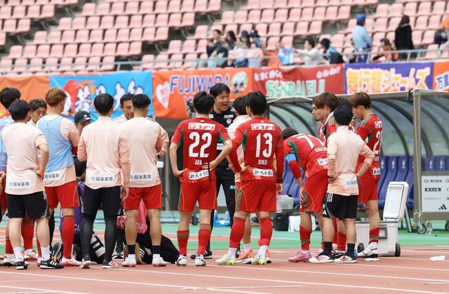 試合終了後、ピッチサイドで円陣を組み、試合の総括を語る新潟の船越優蔵監督=ビッグスワン