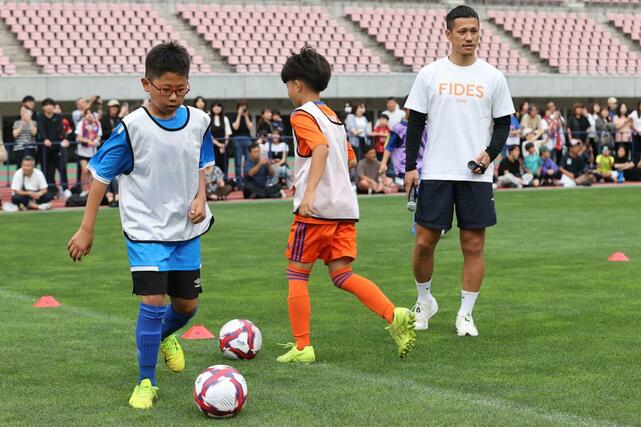 参加した子どもたちを見守るアルビレックス新潟の小野裕二＝６月１４日、デンカビッグスワン