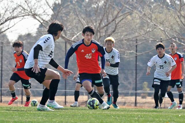J3金沢との練習試合で、ドリブルをする笠井佳祐(中央)=宮崎県西都市