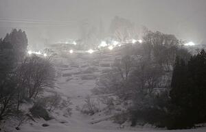 雪上に幻想的な光が浮かび上がった「たいまつ滑降」＝湯沢町湯沢