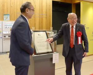 世界遺産登録を証明する認定書を前に、喜びをかみしめる渡辺竜五市長ら=1月18日、佐渡市相川三町目浜町