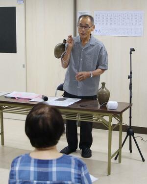 焼酎とっくりの歴史について語る音瀬春三さん=阿賀野市山崎