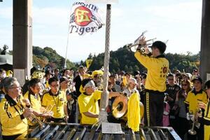 信貴山朝護孫子寺の本堂で、プロ野球阪神タイガースの応援歌を響かせるファンら=16日午後、奈良県平群町