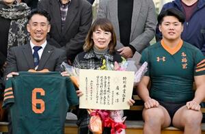 広木淳さんに授与された特別卒業証書を手に記念撮影する母ますみさん(中央)。左はラグビー部のチームメートだった山下昂大さん=11日午後、福岡市の東福岡高
