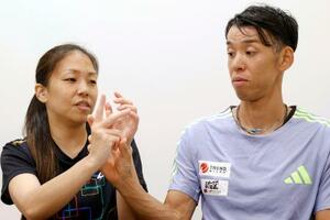 インタビューに応じるデフ陸上男子の高田裕士選手(右)と妻千明選手。2006年に出会った時は、こうして指文字を教わった