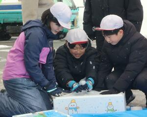 沖縄県の小学校に送る雪を箱に詰める六日町小の５年生＝南魚沼市六日町