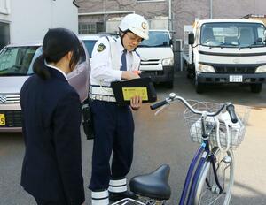 自転車の交通ルールを指導する警察官ら＝１１日、新潟市中央区