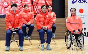 ミラノ・コルティナ冬季五輪・パラリンピックの日本選手団公式スポーツウエアを着用する森重航(手前左)、浮田留衣(奥左)ら=29日、東京都新宿区