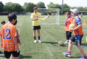 デフサッカーを体験する子どもたちを指導する齋藤心温さん(中央)=新潟市中央区