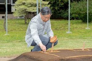 苗代に種もみをまかれる天皇陛下=9日午後、皇居(宮内庁提供)