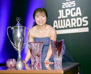 獲得したトロフィーなどを前に笑顔を見せる、最優秀選手賞など個人3冠に輝いた佐久間朱莉=16日、東京都千代田区