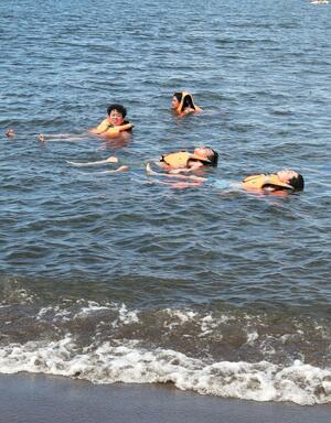 日本海に浮遊し、サウナで火照った体を冷やす人たち=柏崎市鯨波2