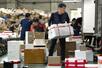 　トラックに荷物を積み込む金載国。奥には配送を待つ荷物が積み上がっていた＝２０２５年１０月、ソウル（撮影・佐藤匠、共同）