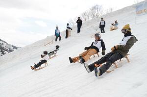 木ぞりで雪上を滑る出場者=魚沼市の奥只見丸山スキー場