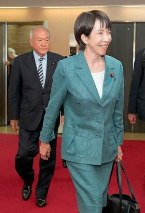 自民党本部に入った高市総裁。左は鈴木幹事長=9日午後、東京・永田町
