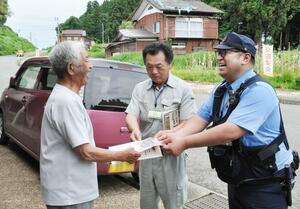 農家にコメや農機具の盗難防止を呼びかけた十日町署員とJA魚沼職員=十日町市松之山湯山