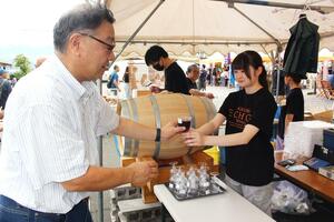 限定販売された赤ワインを楽しむ来場者=南魚沼市浦佐