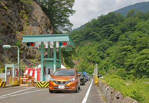 　全線開通した「白山白川郷ホワイトロード」の料金所を通る車＝１２日午前、石川県白山市