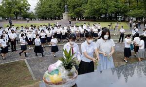 原爆落下中心地碑に献花する高校生平和大使ら=9日午前、長崎市の爆心地公園