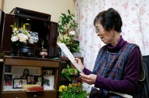 　東日本大震災の津波で亡くなった、娘の村田慶子さんの写真を見つめる鎌谷信子さん＝１月、鳥取市