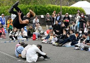 　「大道芸ワールドカップｉｎ静岡２０２５」で、座った子どもたちの上を宙返りで飛び越えるアーティスト＝３１日午後、静岡市