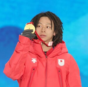2022年の冬季北京五輪のメダルセレモニーで金メダルを見つめる平野歩夢選手=2022年2月