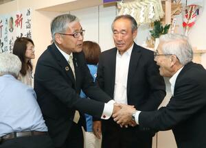 村上市長選で3選を決め、支援者と喜ぶ高橋邦芳氏(左)=6月11日、村上市
