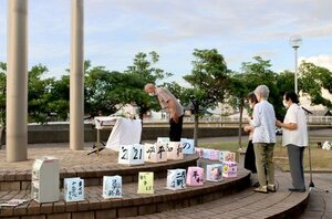 献花台に向かい、犠牲者への祈りをささげる参加者=8日夕、上越市