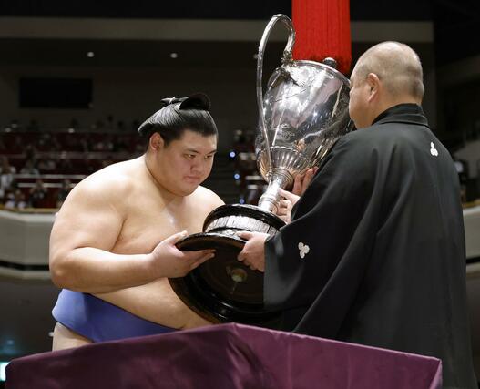 大相撲秋場所で、横綱として初となる優勝を果たし、日本相撲協会の八角理事長（右）から賜杯を受け取る大の里＝２８日、東京・両国国技館