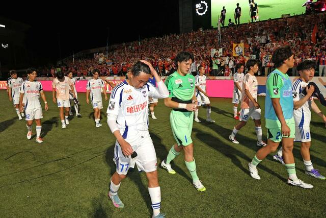 サポーターに挨拶後、悔しそうに引き上げる新潟の選手