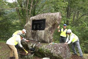 浅野力中尉の慰霊碑を清掃する自衛隊OBら=胎内市下荒沢