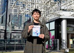 　「渋谷謎解き街歩き」の「キット」を手にする東急不動産の真野知也さん＝東京都渋谷区